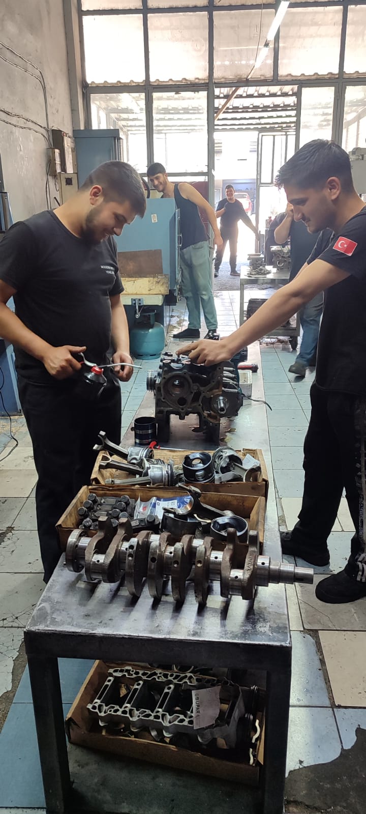 Motor parçası üzerinde çalışan ekip